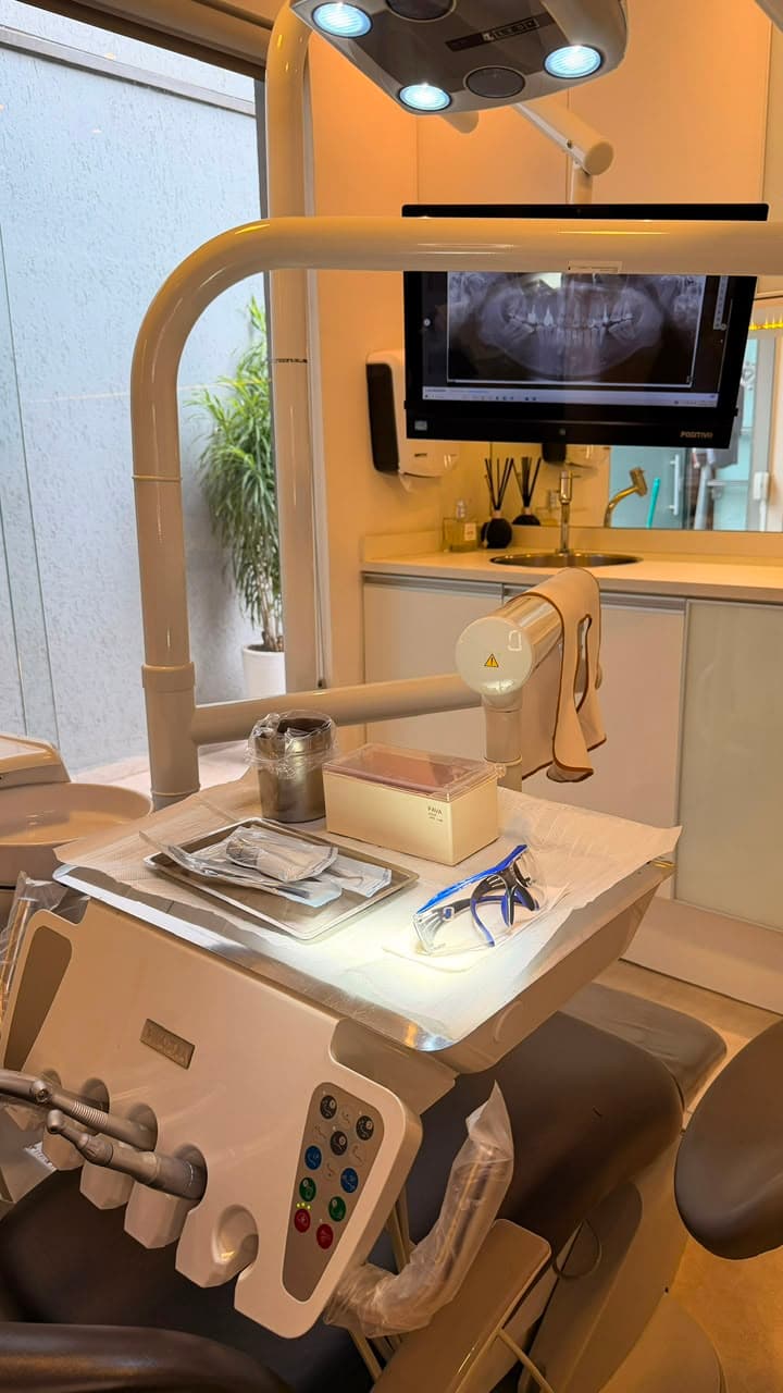 Consultório da Ellos com radiografia panorâmica digital na tela, usada no planejamento do implante dentário